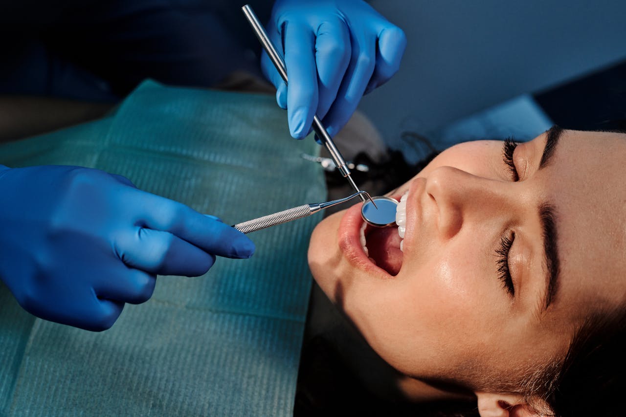 Close-up of a dentist examining a patients teeth using dental tools.