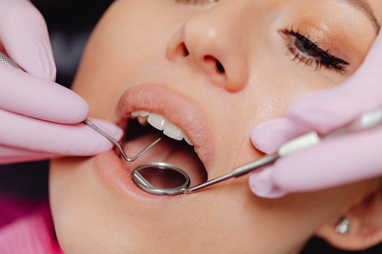 Close-up of a womans dental checkup with a dentist using tools in a clinic.